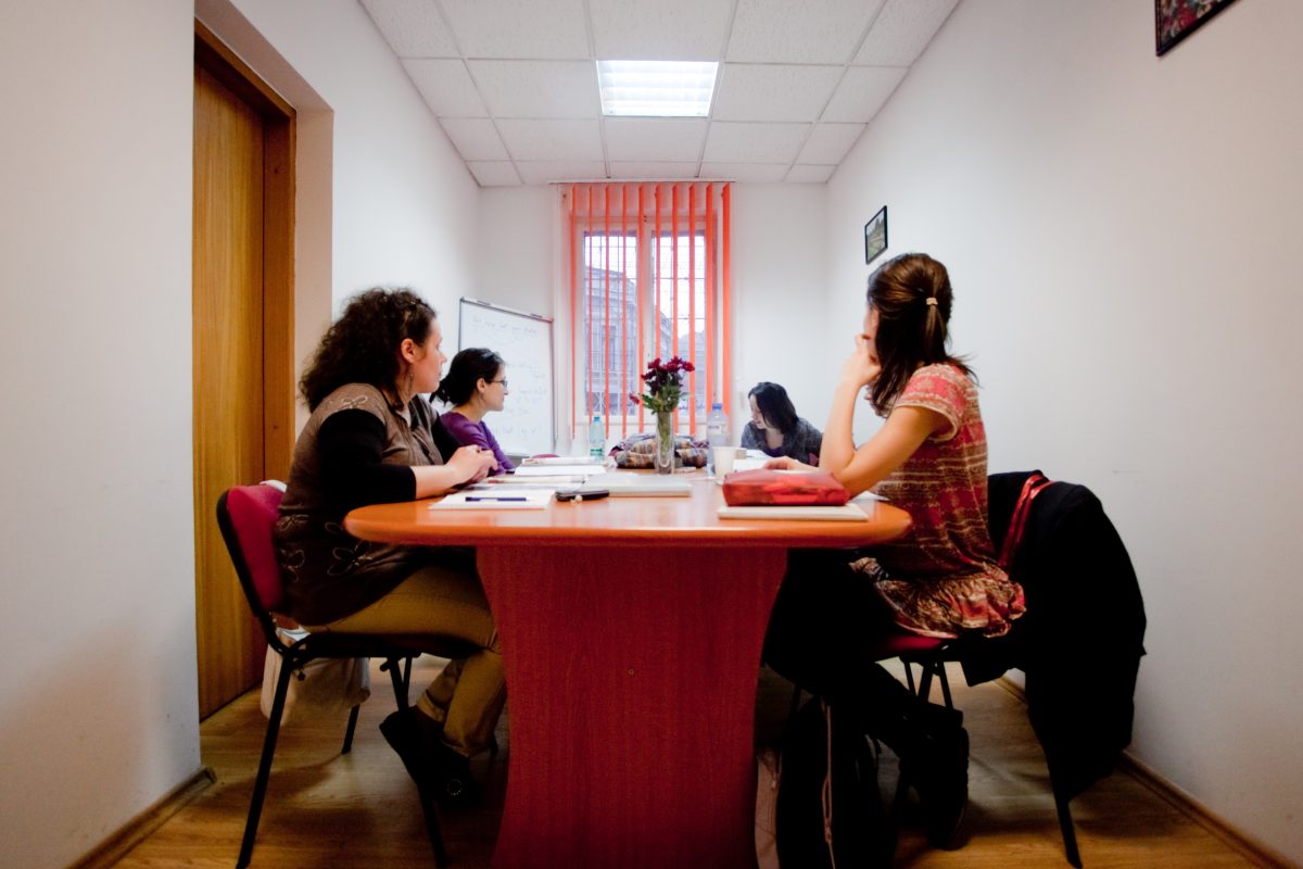 Elevi Echo Kids studiind împreună la o masă, cu materiale de curs